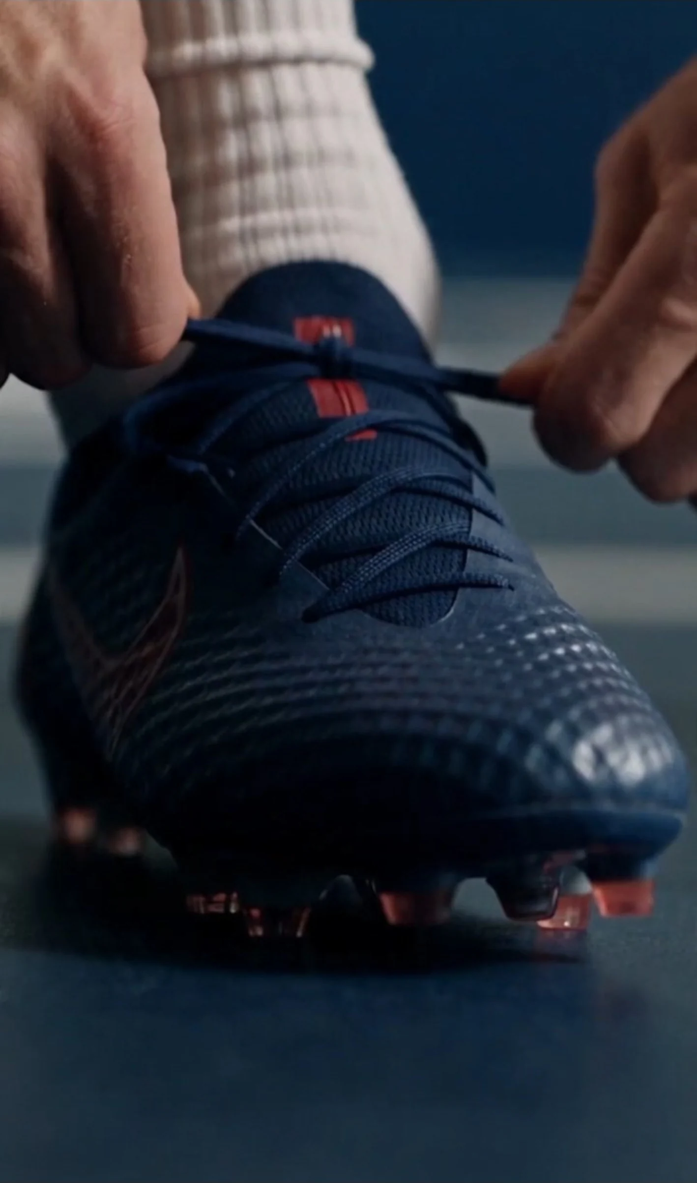 Close-up of hands fastening a football boot before training